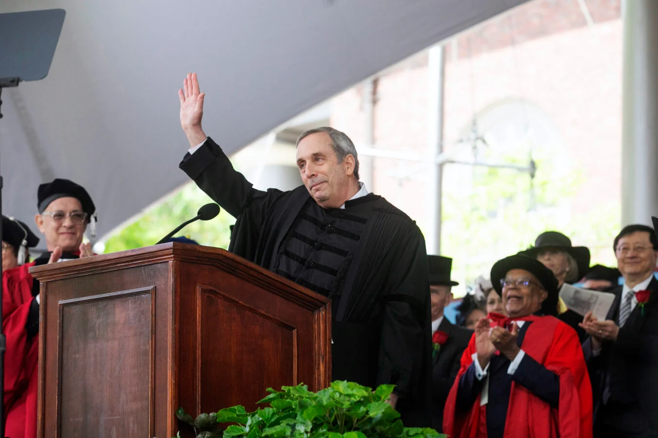 Larry Bacow waves goodbye after delivering his final Commencement address as president. Photo: Jon Chase